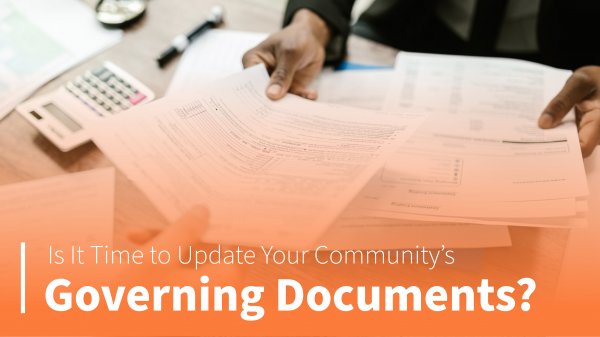 papers on a desk. The text overlay reads, "Is It Time to Update Your Community’s Governing Documents?"