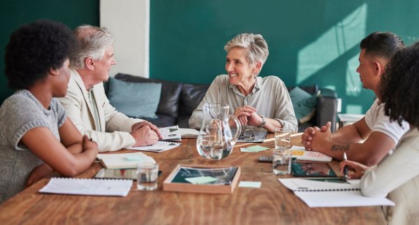 5 people talking at a conference table