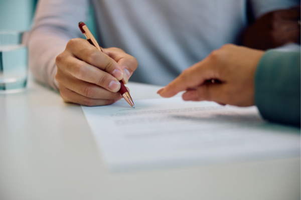 closeup of hands signing documents