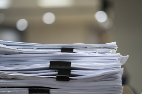 closeup of a stack of papers with black clips